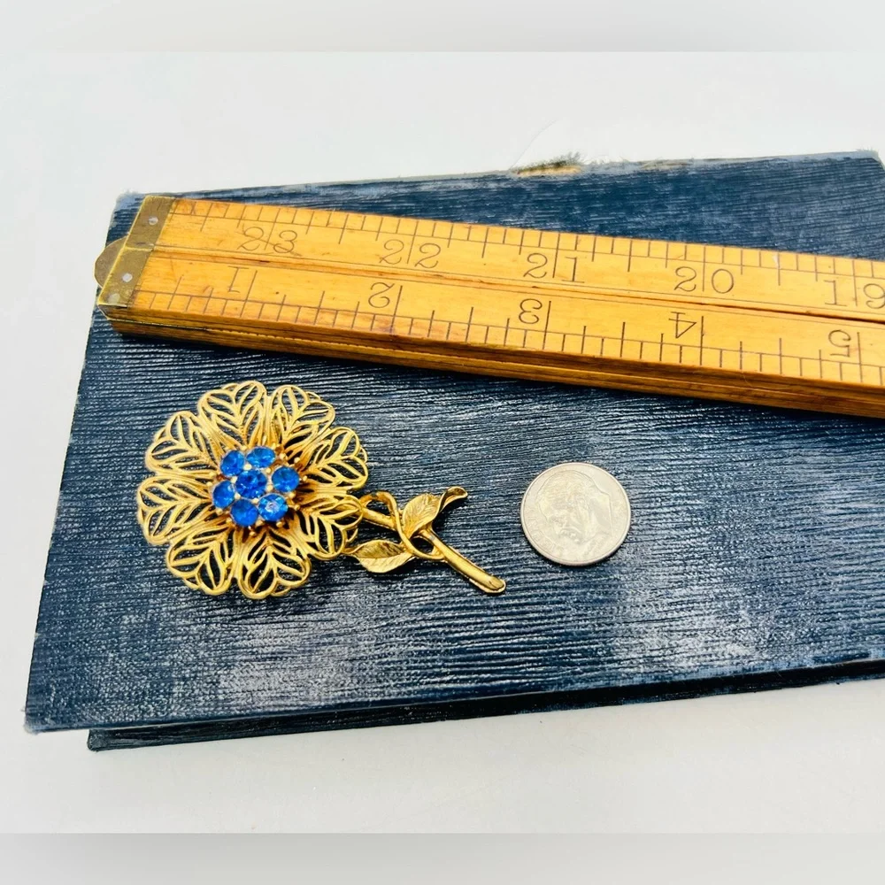 Vintage gold tone filigree flower brooch pin bright blue rhinestones